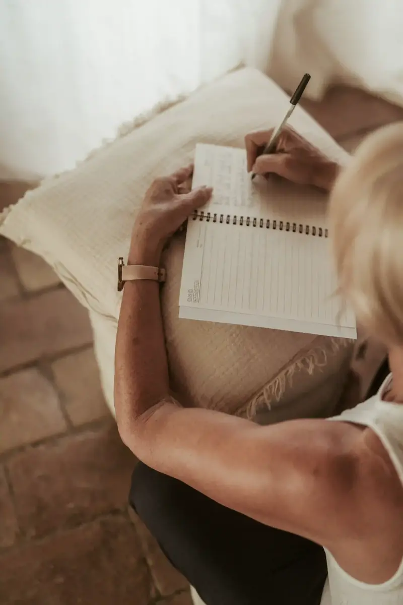 A Zenaa Online member writing in her journal at home, taking a moment for herself