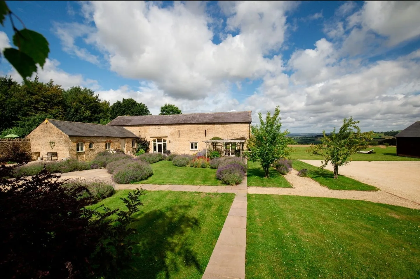 The Farmhouse Barn, framed by lavender borders and open countryside