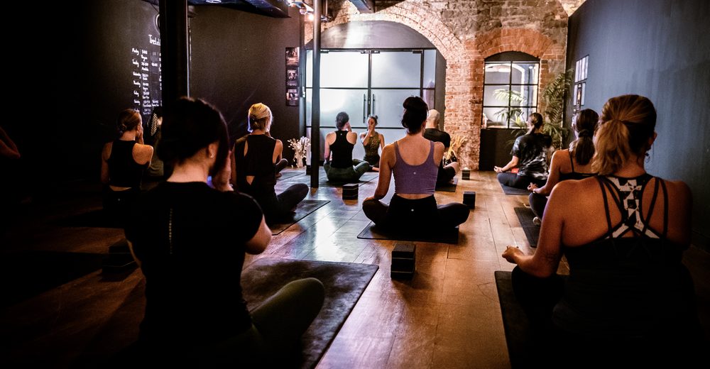 A yoga class sitting in meditation at Yoganand Studio in Bristol