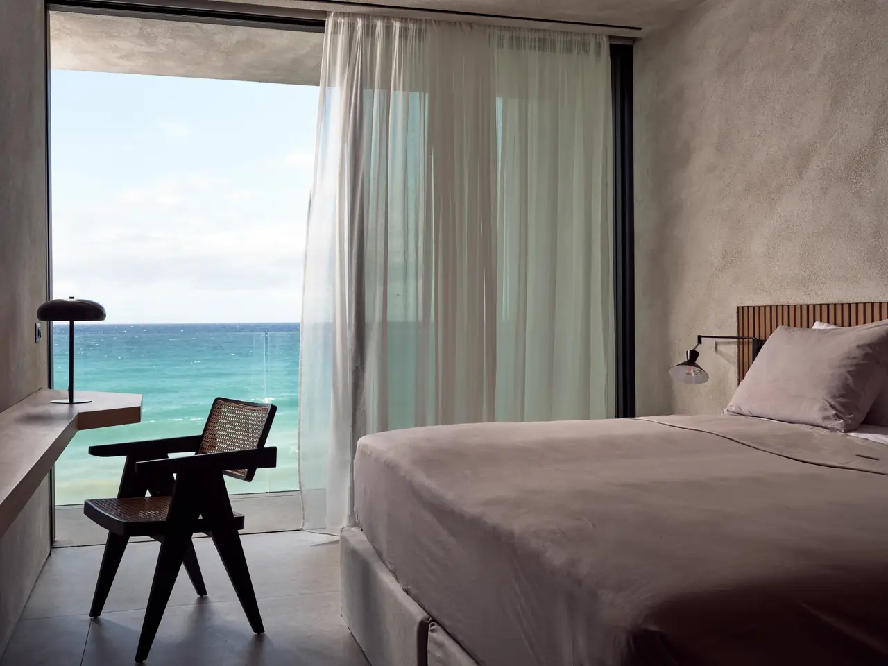 A sea-view bedroom with a writing desk by the window