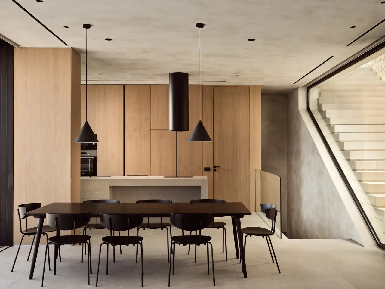 The long dining table beneath pendant lights