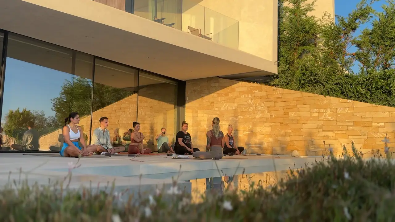Evening yoga by the pool beneath the villa's stone walls