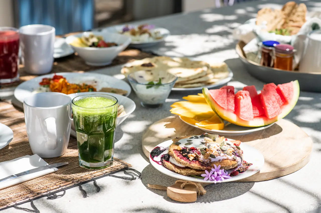 A colourful breakfast spread with fresh fruit, juices and flatbreads