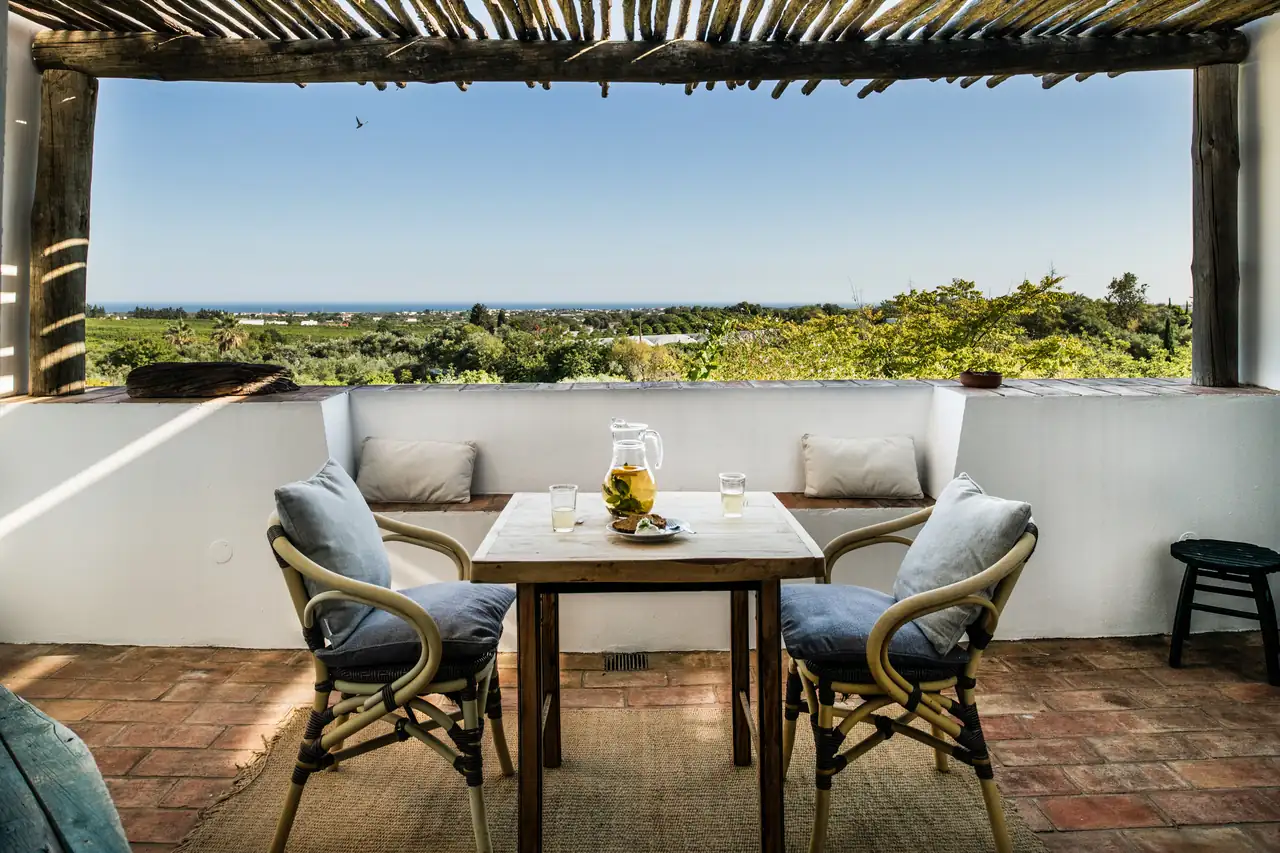 A shaded terrace looking out over the countryside to the sea
