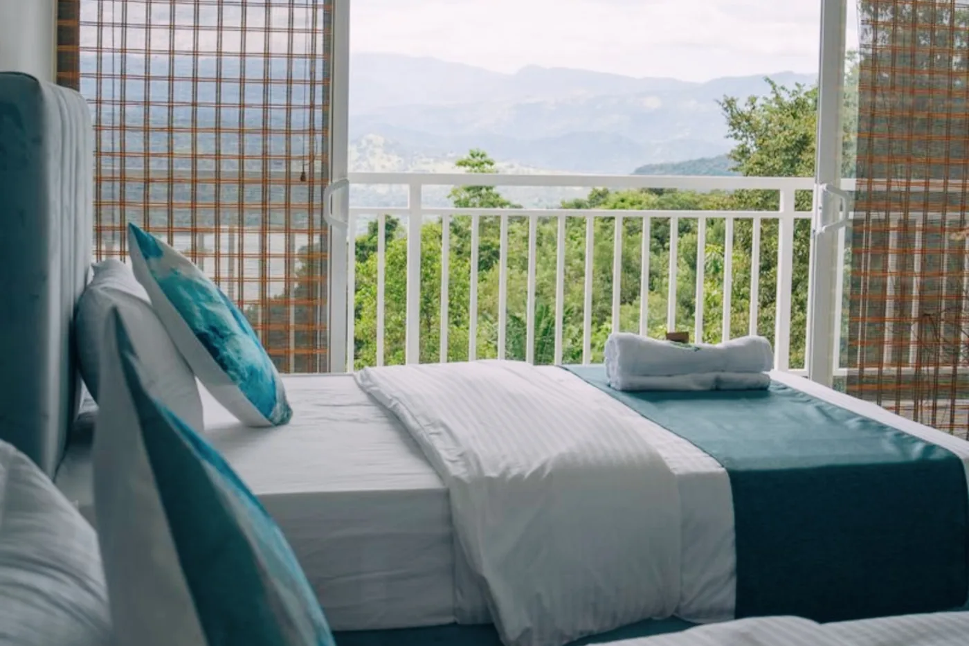 Deluxe twin room with balcony doors open to the mountains at Victoria Folly