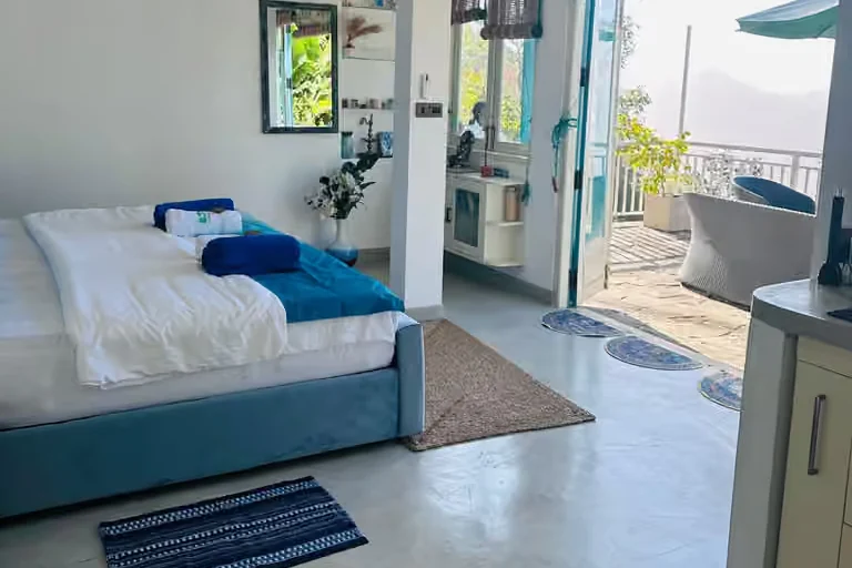Deluxe single room at Victoria Folly with doors open onto a private terrace and mountain views