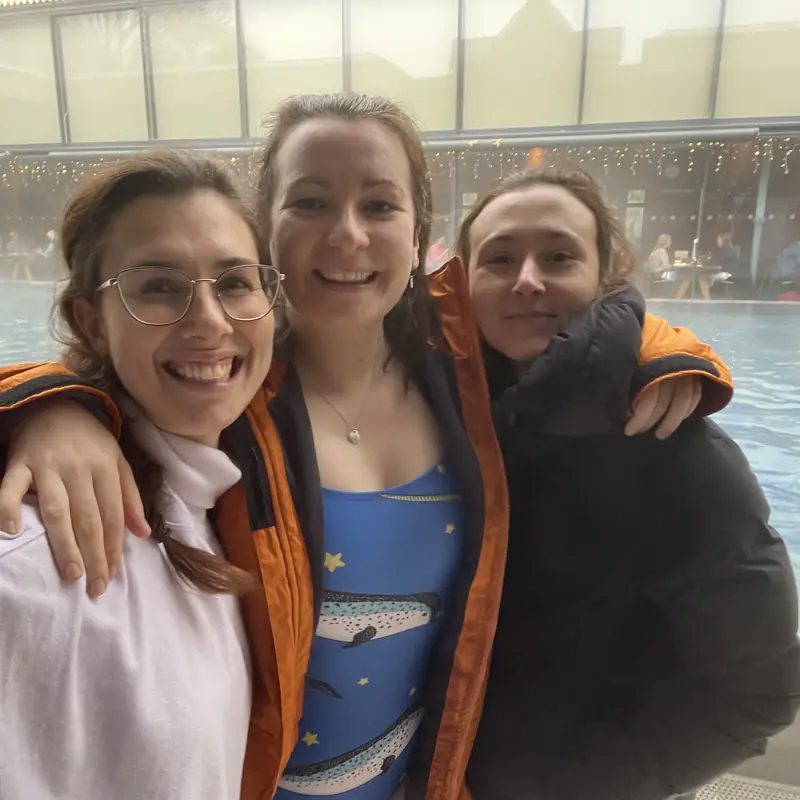 Three friends together beside the pool at a Thames Lido retreat day