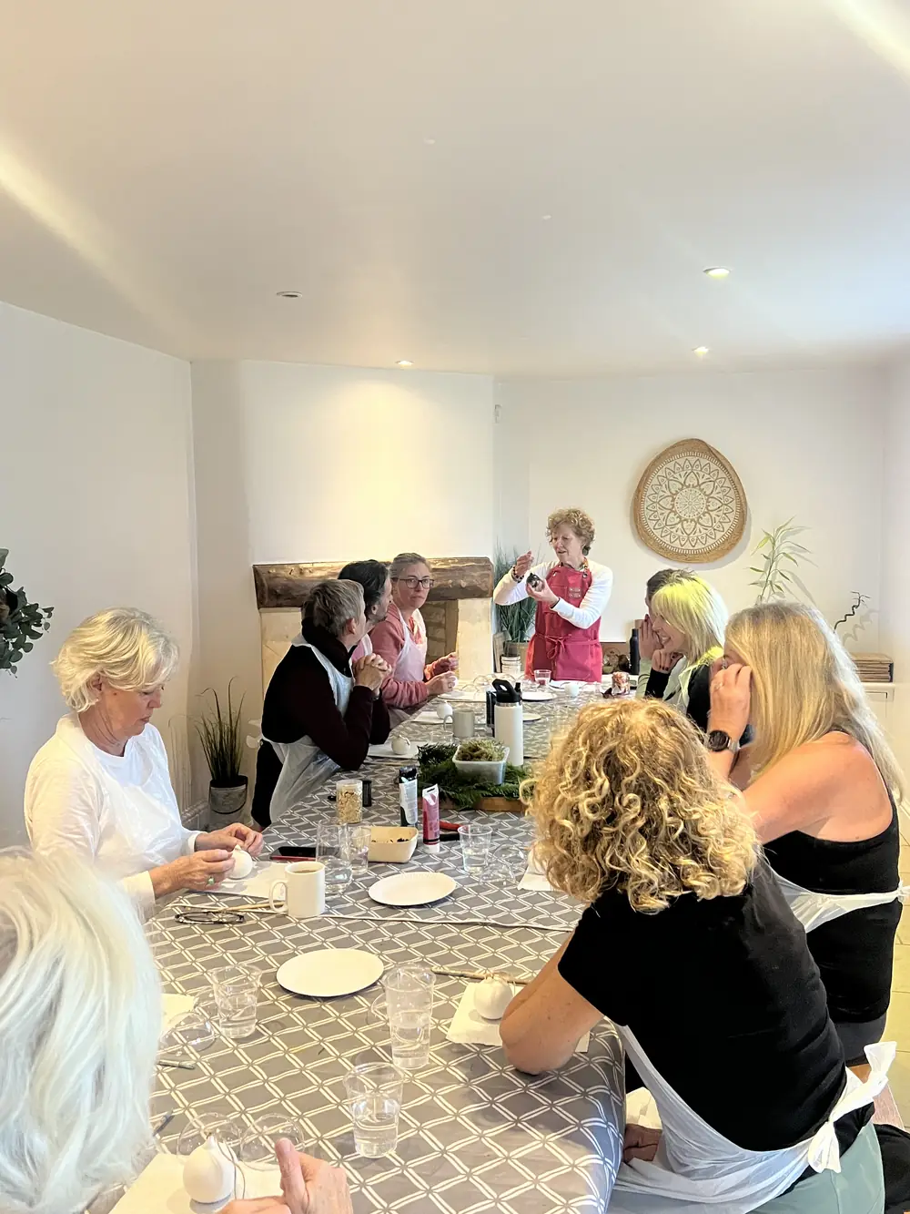 Sue Reeves leading a Christmas centrepiece workshop around a long table
